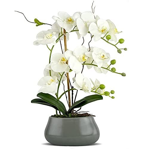 Flores artificiales de orquídea blanca con jarrón gris